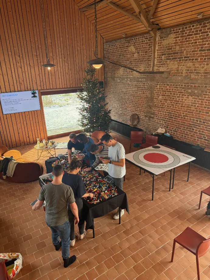 Een groep in gesprek rond modellen op tafel